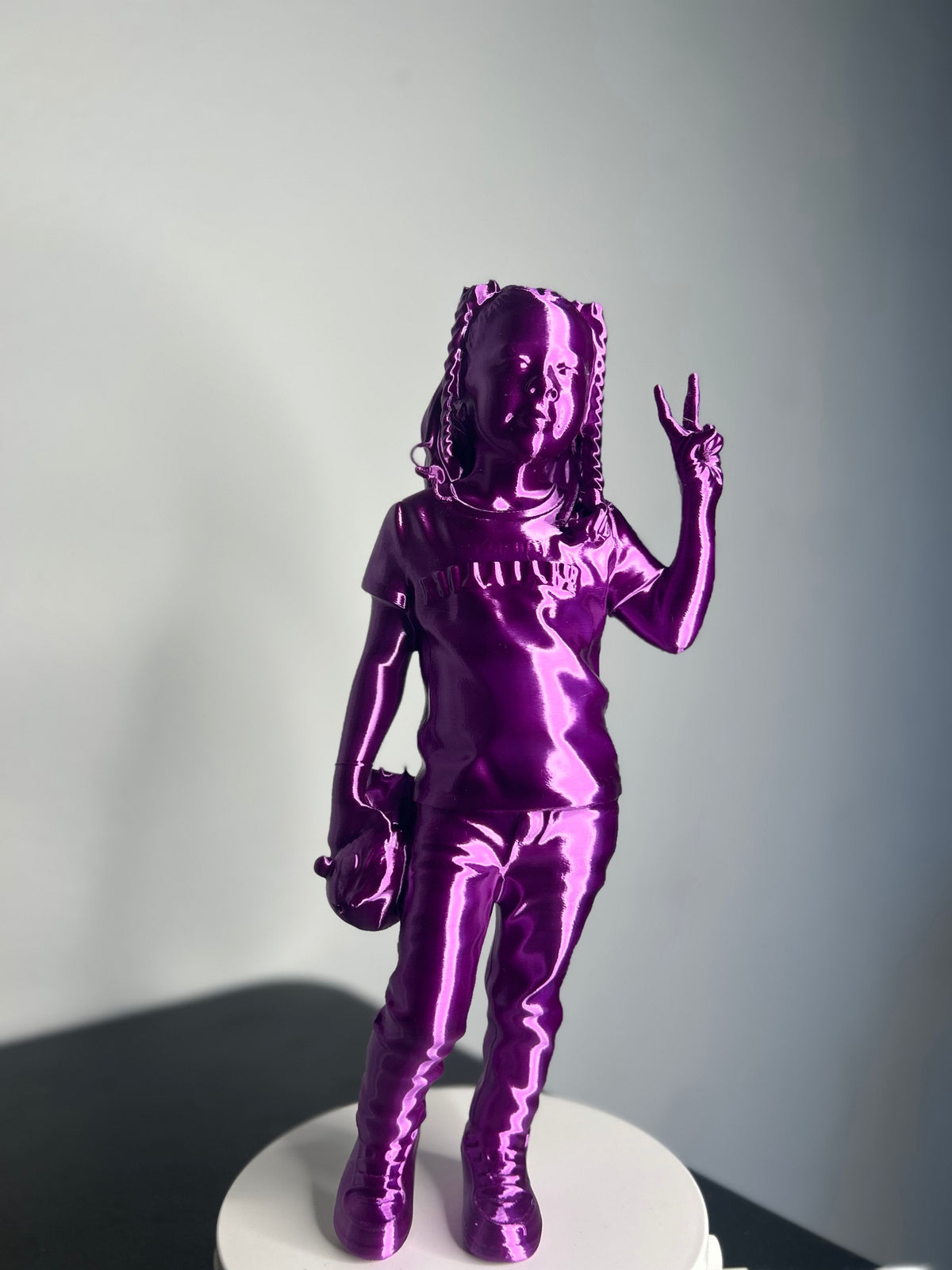 Custom 3D printed figurine of a girl with braids giving a peace sign, metallic purple finish